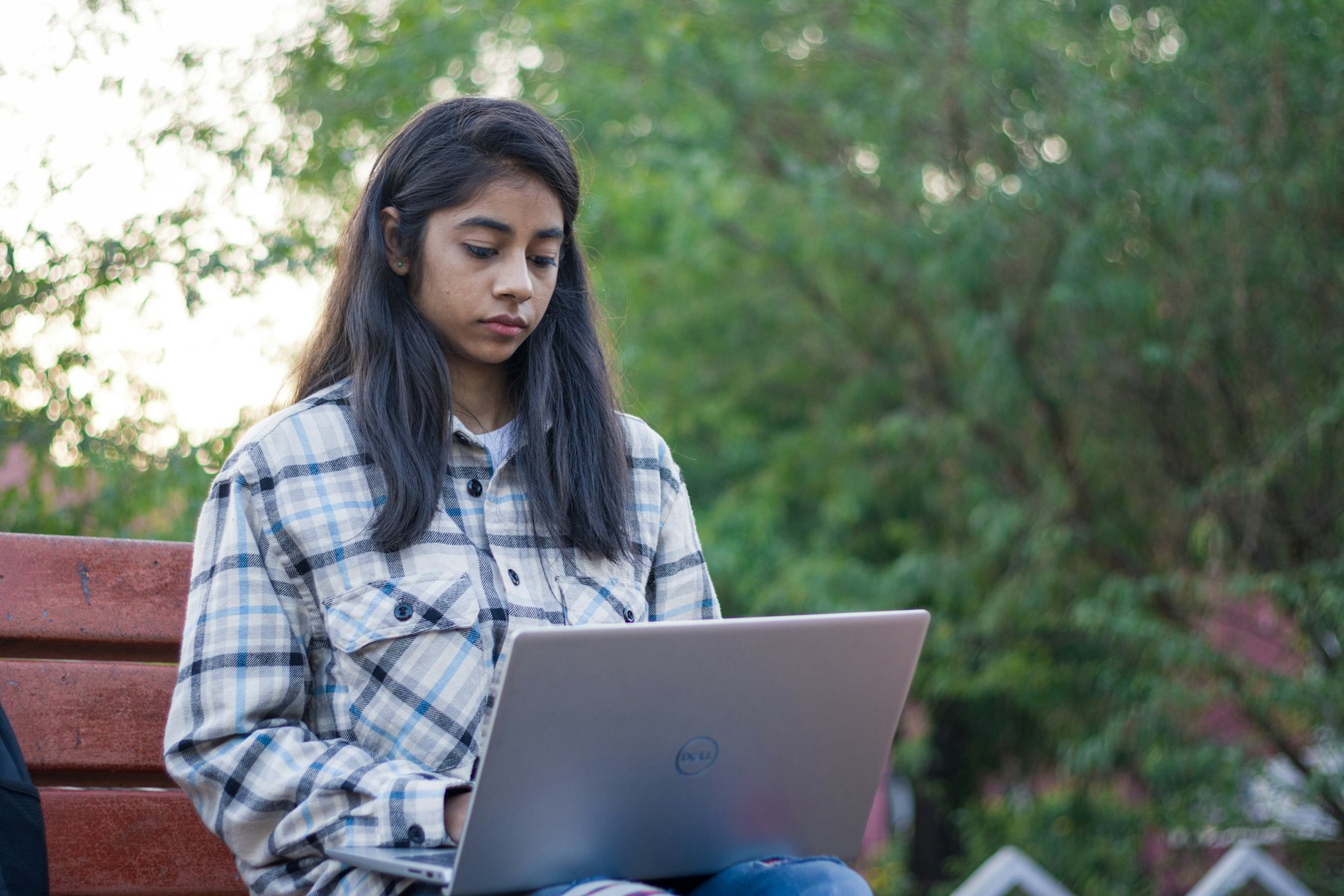 A learner working on a laptop outdoors
